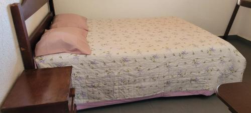 ein Schlafzimmer mit einem Bett mit geblümter Bettdecke in der Unterkunft Casa de Praia na Taiba- Ce in São Gonçalo do Amarante
