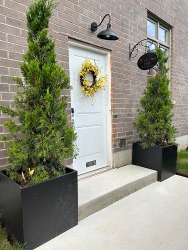 two trees in front of a white door with a wreath at Luxury Executive Studio in Oakville