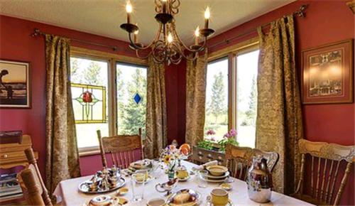 a dining room with a table and a chandelier at Clearview Station & Caboose B&B in Creemore