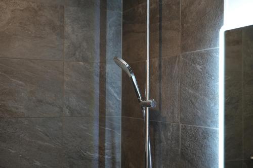 a shower stall with a shower head in a bathroom at Hotel Bergkristall in Silbertal