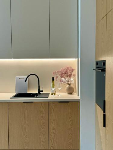 a kitchen counter with a sink and wine glasses at Apartament Premium No 5 - Faktura VAT - Targi Kielce - Parking - Blisko Terenów Zielonych - NEW in Kielce