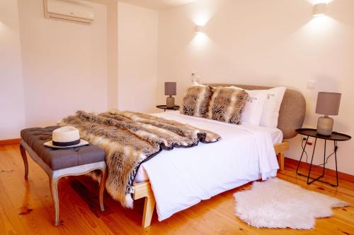 a bedroom with a large white bed with a fur blanket at Authentic Porto Village in Porto