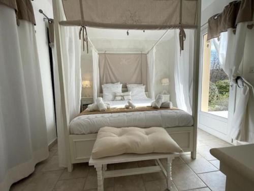 une chambre avec un lit à baldaquin et une fenêtre dans l'établissement Le petit paradis au cœur du Luberon, à Saint-Saturnin-lès-Apt