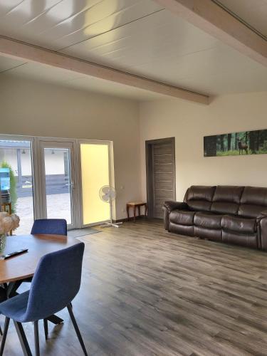 a living room with a leather couch and a table at River Apartment in Līči