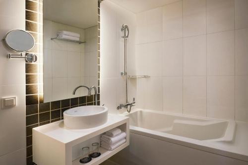 a white bathroom with a sink and a tub at Four Points by Sheraton Seoul, Guro in Seoul