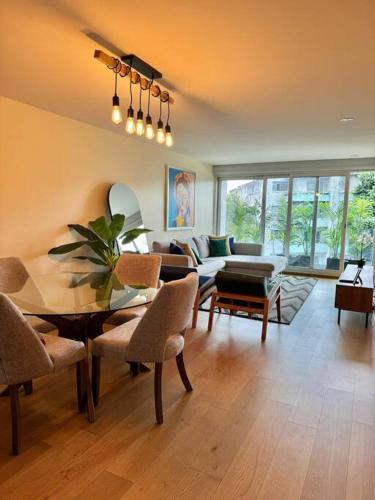 a living room with a table and a couch at Mili & Mila Depto con Alberca y Gym en el corazón de Condesa y Roma in Mexico City