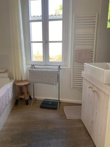 La salle de bains est pourvue d'un lavabo, d'une baignoire et d'une fenêtre. dans l'établissement Filatte, aux Portes