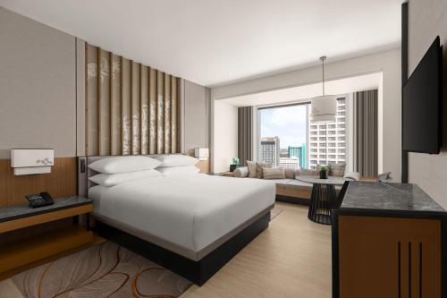 a bedroom with a bed and a living room at Chiang Mai Marriott Hotel in Chiang Mai