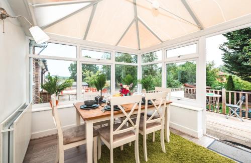 a conservatory dining room with a table and chairs at Family Gathering Bungalow in Southampton