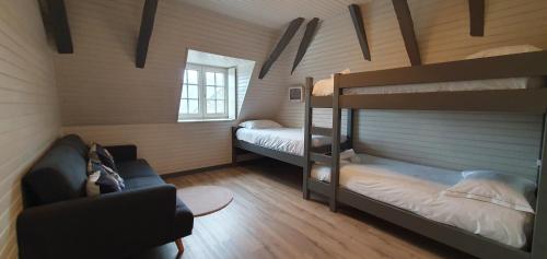 a room with two bunk beds and a couch at Gîte château d'Espalungue, piscine et SPA in Dognen