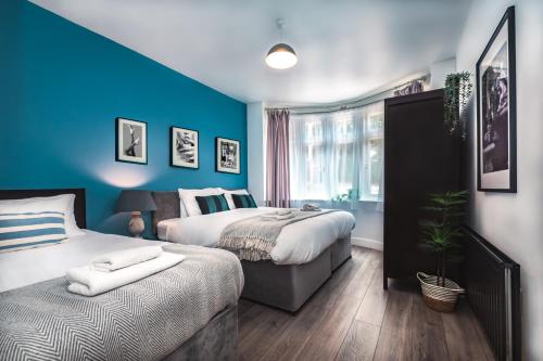 ein Schlafzimmer mit zwei Betten und einer blauen Wand in der Unterkunft Family Gathering Bungalow in Southampton