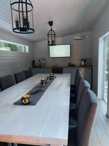 a long table in a room with chairs and a screen at Villa Falco in Espoo