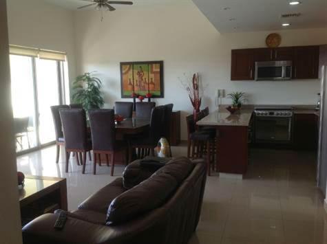 ein Wohnzimmer mit Couch und Tisch und eine Küche in der Unterkunft GAVIAS GRANd in La Florida