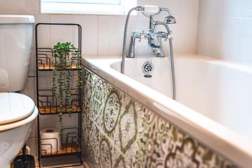 ein Badezimmer mit Badewanne und Toilette in der Unterkunft Family Gathering Bungalow in Southampton