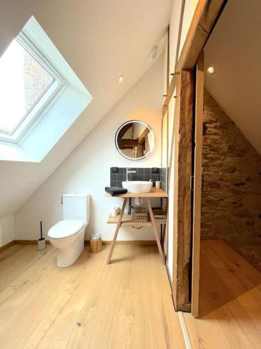 La salle de bains mansardée est pourvue d'un lavabo et de toilettes. dans l'établissement Charmante Maison Rustique, à Piriac-sur-Mer