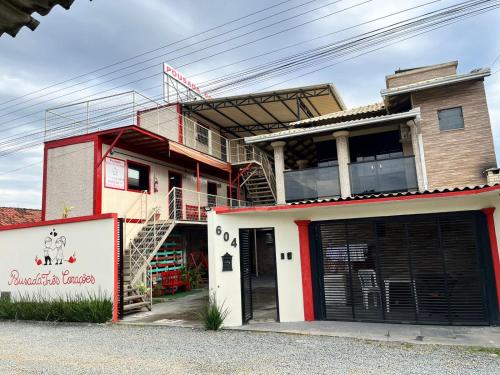 a building with two garage doors in front of it at Pousada Três Corações in Penha