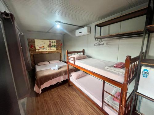 a small room with two bunk beds in it at Pousada Três Corações in Penha