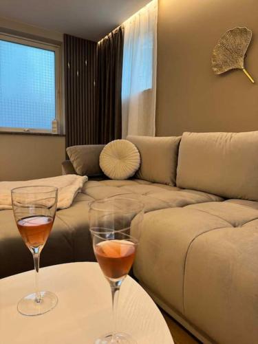 two wine glasses sitting on a table in front of a couch at Arctic feathers in Narvik