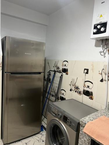 a kitchen with a refrigerator and a washing machine at Appartement cosy près de la plage Anza , Agadir in Agadir