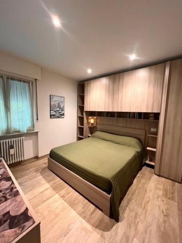a bedroom with a green bed in a room at Casa di Chiara Andalo Centro in Andalo