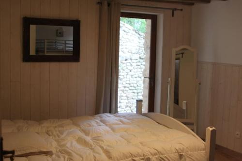 une chambre avec un lit et une grande fenêtre dans l'établissement Ecogîte Les jours heureux Chalo, à Châlo-Saint-Mars