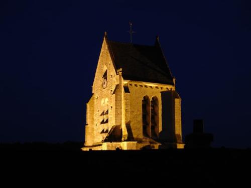 une église avec une tour d'horloge la nuit dans l'établissement Ecogîte Les jours heureux Chalo, à Châlo-Saint-Mars