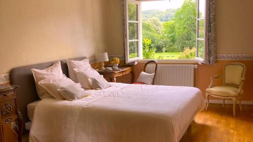 a bedroom with a white bed with a window at CHEZ PIERRE in Remoncourt