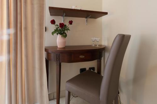 a table with a vase of flowers and a chair at Villa Aurelia Pompei in Pompei