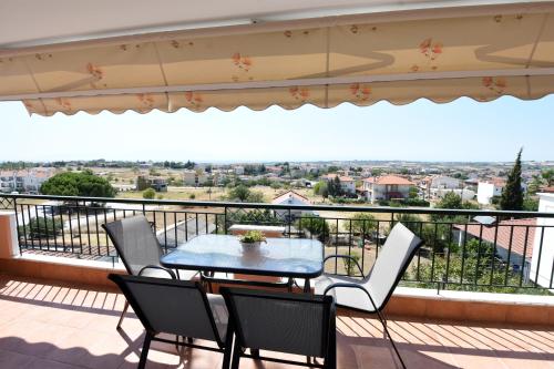 a patio with a table and chairs on a balcony at Lux Mint Apartment - A modern Luxury place with Sea View in Epanomi