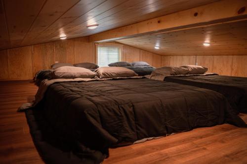 a room with three beds in a wooden room at the together place in Seward