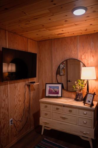 a room with a dresser with a tv and a mirror at the together place in Seward