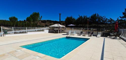 a swimming pool with chairs and an umbrella at Quinta da Libelinha Alojamento Local - Mirandela in Mirandela