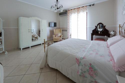 a bedroom with a bed and a chair and a window at Villa Aurelia Pompei in Pompei