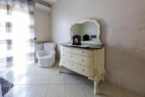 a dresser with a mirror and a chair in a room at Villa Aurelia Pompei in Pompei