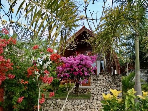 a garden with flowers in front of a house at Jungle Paradise in Nusa Penida