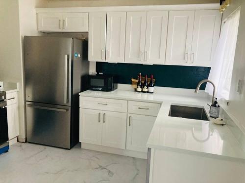a kitchen with white cabinets and a stainless steel refrigerator at 1940s Urban charmer modern upgrades in Auburn