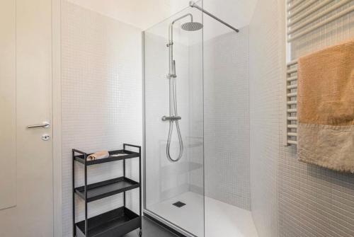 un bagno con doccia con porta in vetro di Tofane sky loft a Treviso