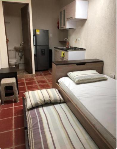 a small kitchen with two beds in a room at Apartaestudios contiguos cerca al Centro Comercial Fabricato in Bello