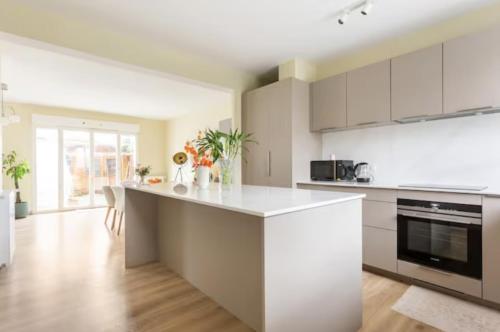 une cuisine avec des placards blancs et un comptoir blanc dans l'établissement Peaceful room in a modern house, à Bordeaux