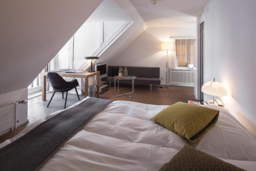 Schlafzimmer mit einem großen weißen Bett und einem Schreibtisch in der Unterkunft Baseltor Hotel & Restaurant in Solothurn