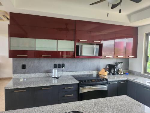 a kitchen with purple cabinets and a stove top oven at Casa Brisa Azul in Tangolunda