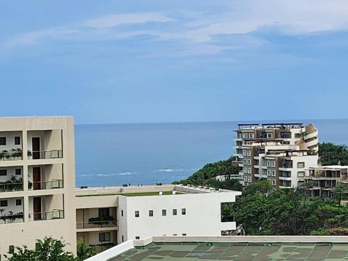 a view of some apartment buildings and the ocean at Casa Brisa Azul in Tangolunda