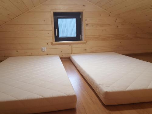 two beds in a room with a window at Domek Leon in Okuninka