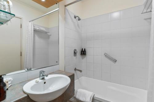 a white bathroom with a sink and a tub at Copthorne Hotel Rotorua in Rotorua