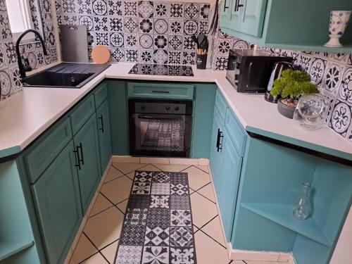 Il comprend une cuisine avec des placards bleus et du carrelage. dans l'établissement Appartement Coeur de Troyes, à Troyes