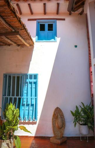 a white building with blue windows and plants at Aura Hotel Parque Barichara By Infinity in Barichara