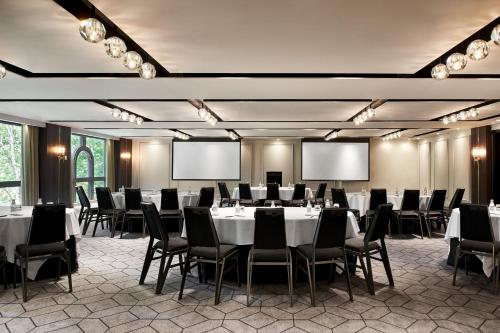 a conference room with tables and chairs and screens at Sheraton Grand Sydney Hyde Park in Sydney