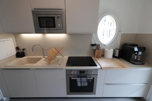 une petite cuisine avec un évier et une cuisinière dans l'établissement Chez Corentin, à Puteaux