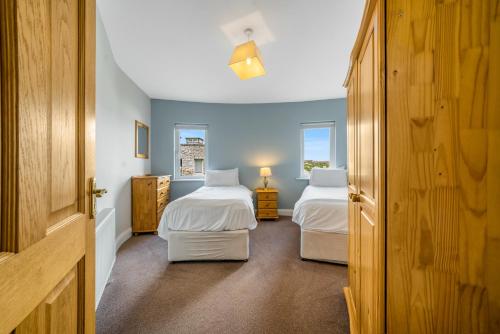 two beds in a room with two beds sidx sidx sidx sidx sidx sidx at Downings Coastguard Cottages - Type B-E in Downings
