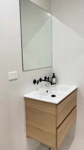 a bathroom with a sink and a mirror at Surfside Retreat-Stylish Escape in Bulli